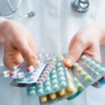 Hand of doctors holding many different pills
